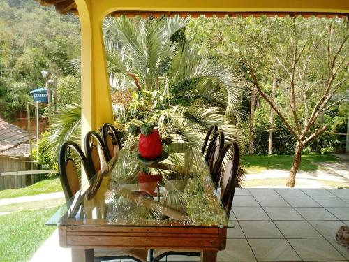 a glass table with a red apple on top of it at Casa com Flores in Pedra Azul