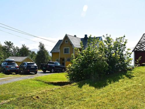 a yellow house with cars parked in front of it at 6 person holiday home in FISK in Fiskå