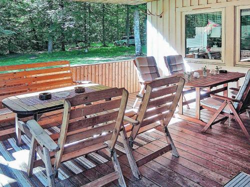 une table et des chaises en bois sur une terrasse en bois dans l'établissement 6 person holiday home in H STVEDA, à Hästveda