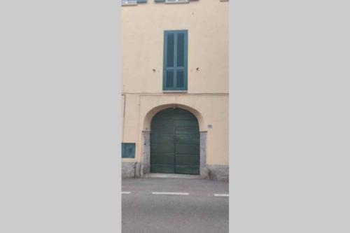 a green garage door on a white building at Apartment in Lurago Derba - Como Provinz 42304 in Lurago D'Erba 
