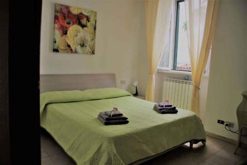 a bedroom with a green bed with two towels on it at Apartment in Lurago Derba - Como Provinz 42304 in Lurago D'Erba 