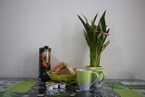 a table with cups and a vase with a plant at Apartment in Lurago Derba - Como Provinz 42304 in Lurago D'Erba 