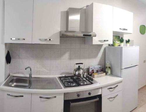 a white kitchen with a stove and a sink at Apartment in Lurago Derba - Como Provinz 42304 in Lurago D'Erba 