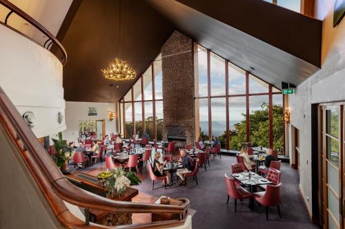 a restaurant with tables and chairs and large windows at Fairmont Resort Blue Mountains MGallery Collection in Leura