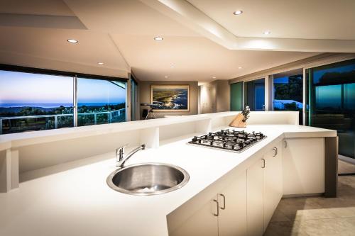 una cocina con fregadero y estufa en Horizons House - spacious, ocean + bush views, peaceful, en Margaret River Town