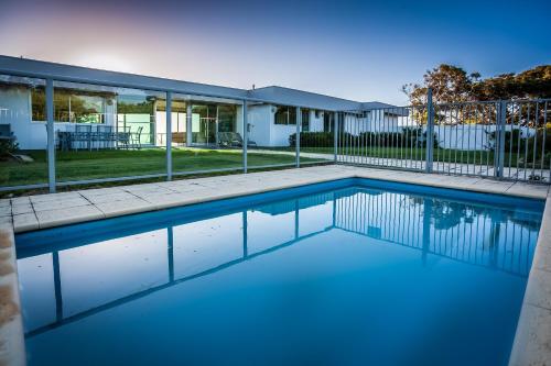 a swimming pool in front of a house at Horizons House - spacious, ocean + bush views, peaceful in Margaret River Town