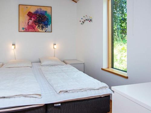 Schlafzimmer mit einem großen Bett und einem Fenster in der Unterkunft Holiday home Ebeltoft CLXVI in Ebeltoft