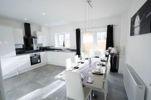 una cucina e una sala da pranzo con tavolo e sedie di Entire Modern Home with Private Parking for 6/8 Persons a Worksop