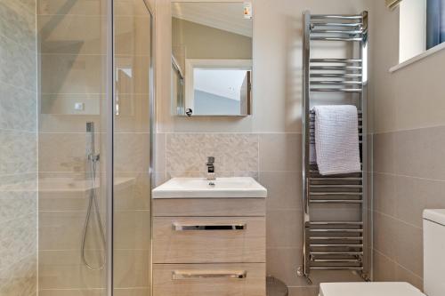 a bathroom with a sink and a shower at Ael-Y-Bryn - Luxury Lodge, Hot Tub, Three En-Suite Bedrooms in Penally