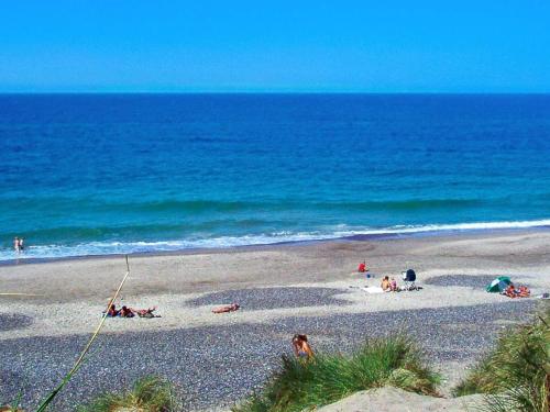 un groupe de personnes sur une plage près de l'océan dans l'établissement 4 person holiday home in Ringk bing, à Ringkøbing