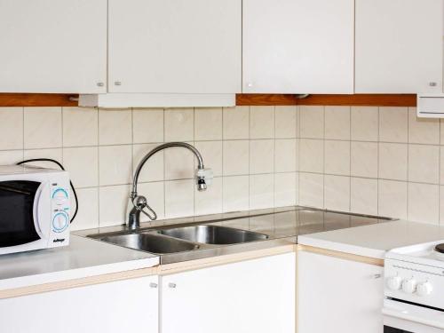 泰爾貝里的住宿－Apartment TÄLLBERG，厨房配有水槽和微波炉