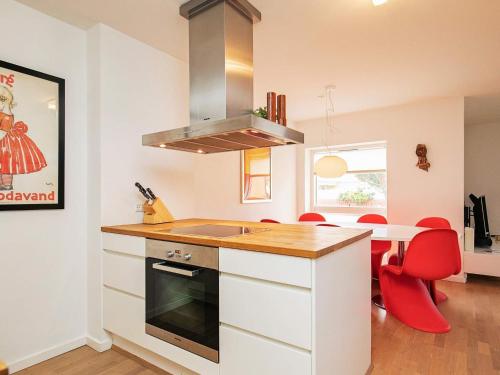 - une cuisine avec un comptoir et des chaises rouges dans l'établissement 6 person holiday home in Skagen, à Skagen