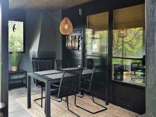 a dining room with a table and black chairs at 4 person holiday home in VEBER D in Veberöd