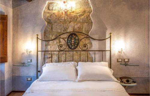1 dormitorio con 1 cama con pared de piedra en Firminia, en Scheggino