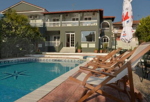 a house with a swimming pool in front of a house at Hotel Villa Drosos in Litochoro