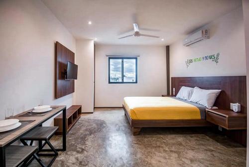 a bedroom with a bed and a desk and a television at dewl estudios : El Mexicano in Playa del Carmen