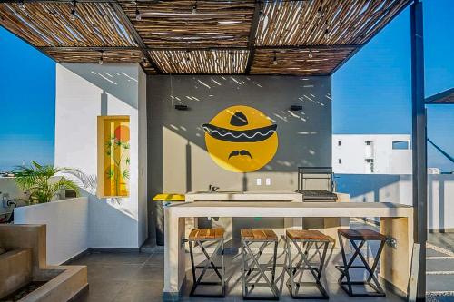 a dining room with a table with chairs and a yellow face on the wall at Great Villas estudios - El Mexicano in Playa del Carmen