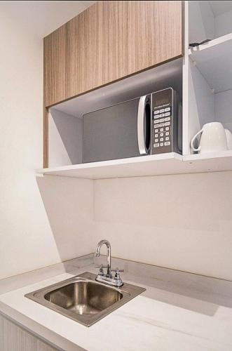 a kitchen with a sink and a microwave at Great Villas estudios - El Mexicano in Playa del Carmen