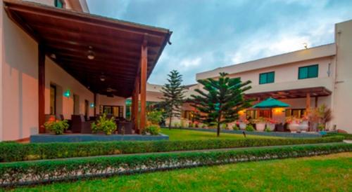 a building with a green lawn in front of it at Fiesta Royale Hotel in Accra
