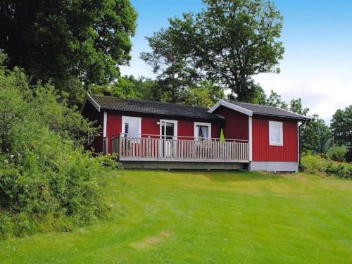una pequeña casa roja con balcón en un patio en 4 person holiday home in HEN N, en Henån