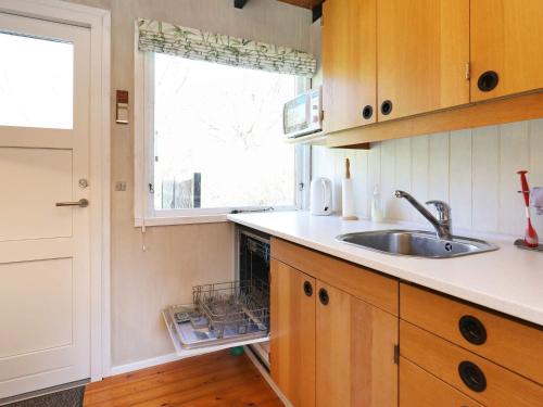 una pequeña cocina con fregadero y ventana en 6 person holiday home in Stege, en Stege