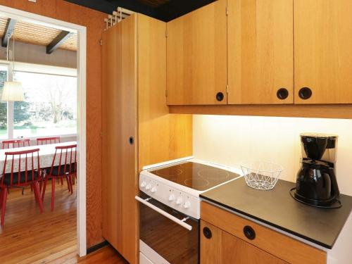 a kitchen with a stove top oven next to a table at 6 person holiday home in Stege in Stege