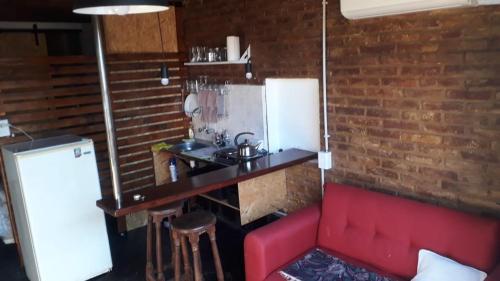 a kitchen with a red couch and a brick wall at FG in Tolosa