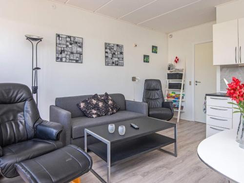 een woonkamer met een bank en een tafel bij 4 person holiday home in R m in Sønderby