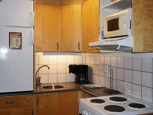 uma cozinha com um frigorífico branco e um lavatório em 4 person holiday home in S LEN em Stöten