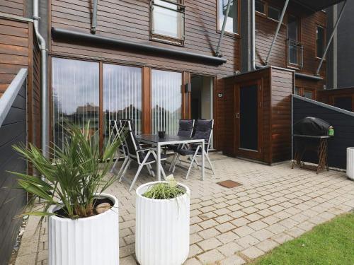 a patio with a table and chairs and plants at 4 person holiday home in Bogense-By Traum in Bogense