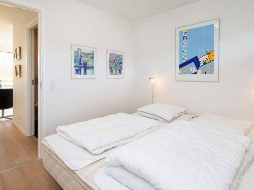 een witte kamer met een bed met witte lakens bij Apartment Bogense IV in Bogense