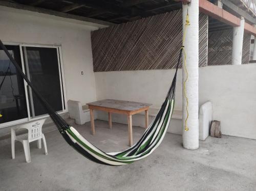 a hammock in a room with a table and a bench at Club Cadena in Acapulco