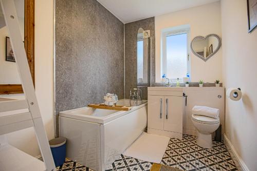 a white bathroom with a toilet and a sink at Detached House with Free Parking, Garden, Fast Wifi and Smart TV with Netflix by Yoko Property in Milton Keynes