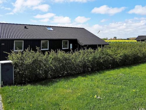 una casa negra en medio de un campo en 9 person holiday home in Otterup, en Otterup
