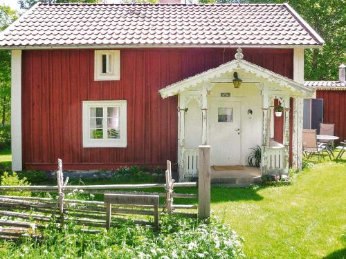 een rood-wit huis met een prieel bij 5 person holiday home in LAMMHULT in Lammhult