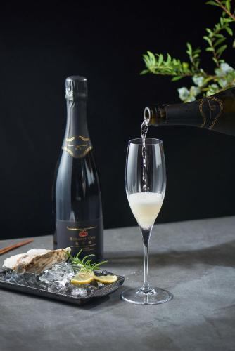 a bottle of wine and a glass of white wine at Runaway Cow Winery Retreat in Yantai