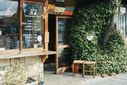 ein Geschäft mit zwei Hockern vor einem Gebäude in der Unterkunft Gojo Guest House in Kyoto