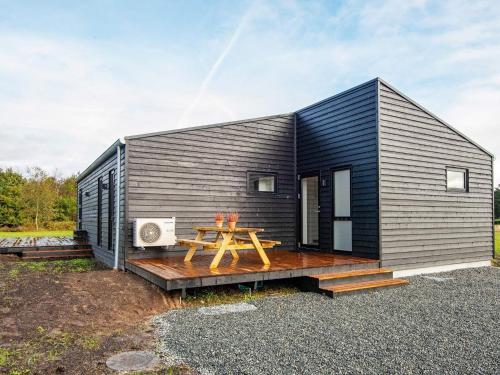 uma pequena casa preta com uma mesa de piquenique em 8 person holiday home in Ansager em Ansager