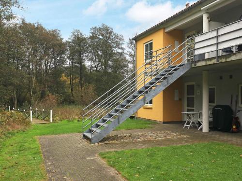 a staircase on the side of a yellow house at 4 person holiday home in Hals-By Traum in Hals