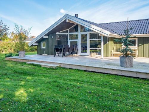 ein Haus mit einer großen Terrasse mit einem Tisch und Stühlen in der Unterkunft 8 person holiday home in Sydals in Skovmose