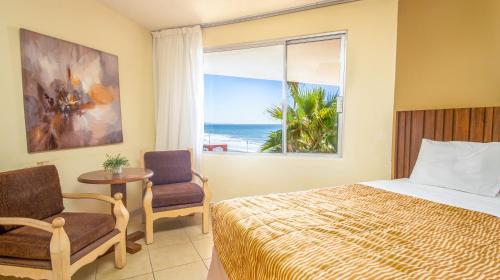 ロサリトにあるPuerto Nuevo Baja Hotel & Villasのベッドルーム1室(ベッド1台、海の景色を望む窓付)が備わります。