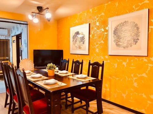 a dining room with a wooden table and chairs at Art House in Osaka