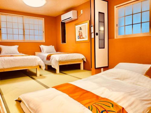 a room with two beds and two windows at Art House in Osaka