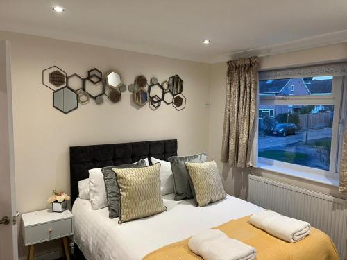 a bedroom with a large bed and a window at FW Haute Apartments at Stanmore, 3 Bedrooms and 1 Bathroom with additional WC, Single or Double Beds, Pet Friendly Flat with FREE WIFI and FREE PARKING in Stanmore