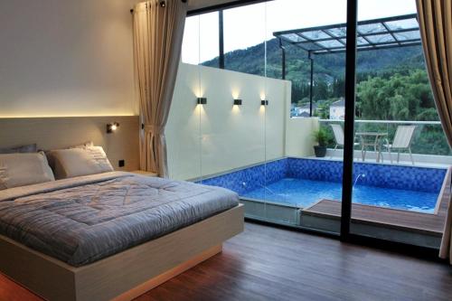 a bedroom with a bed and a swimming pool at villa view2 sayriah in Puncak
