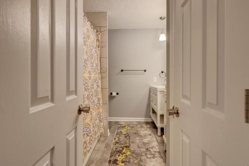 a white bathroom with a sink and a door at #111 Elaborate Condo Ideal Location 2BRM/2 Parking in Hilton Head Island
