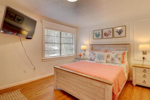 a bedroom with a bed and a tv on the wall at #114 Colorful Charming Condo 2BDR/2 Parking in Hilton Head Island