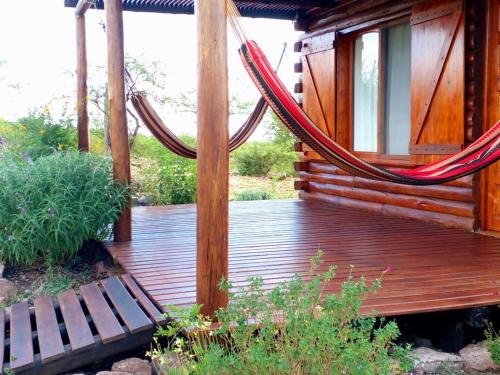 a wooden deck with a hammock on a cabin at Monte Sion cabañas & relax in San Javier
