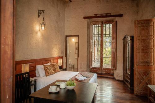 a bedroom with a bed and a table in a room at La Casa de Melgar in Arequipa