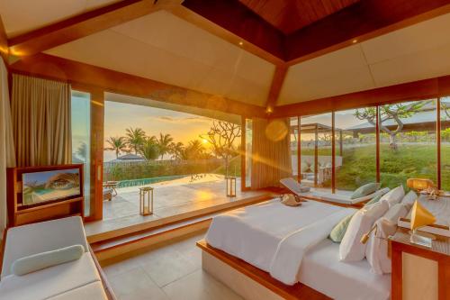 a bedroom with a large bed and a large window at Fusion Resort Cam Ranh - All Spa Inclusive in Cam Ranh
